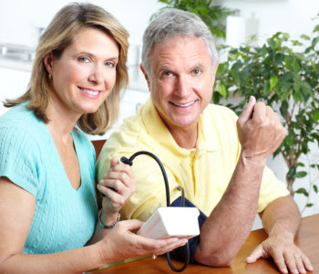 nurse checking the blood pressure of elder man